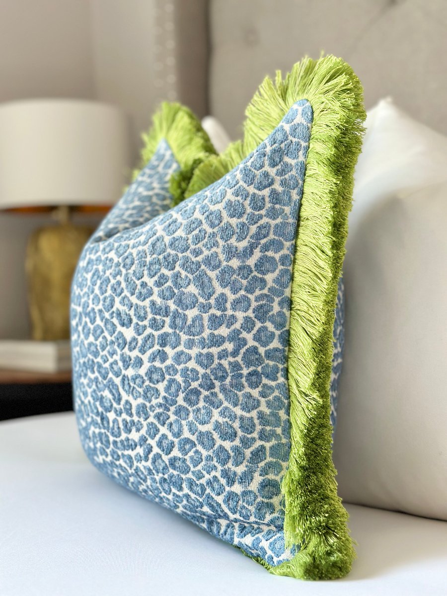 Blue cheetah print throw pillow cover with vibrant green fringe detail , adding a bold touch of color and texture