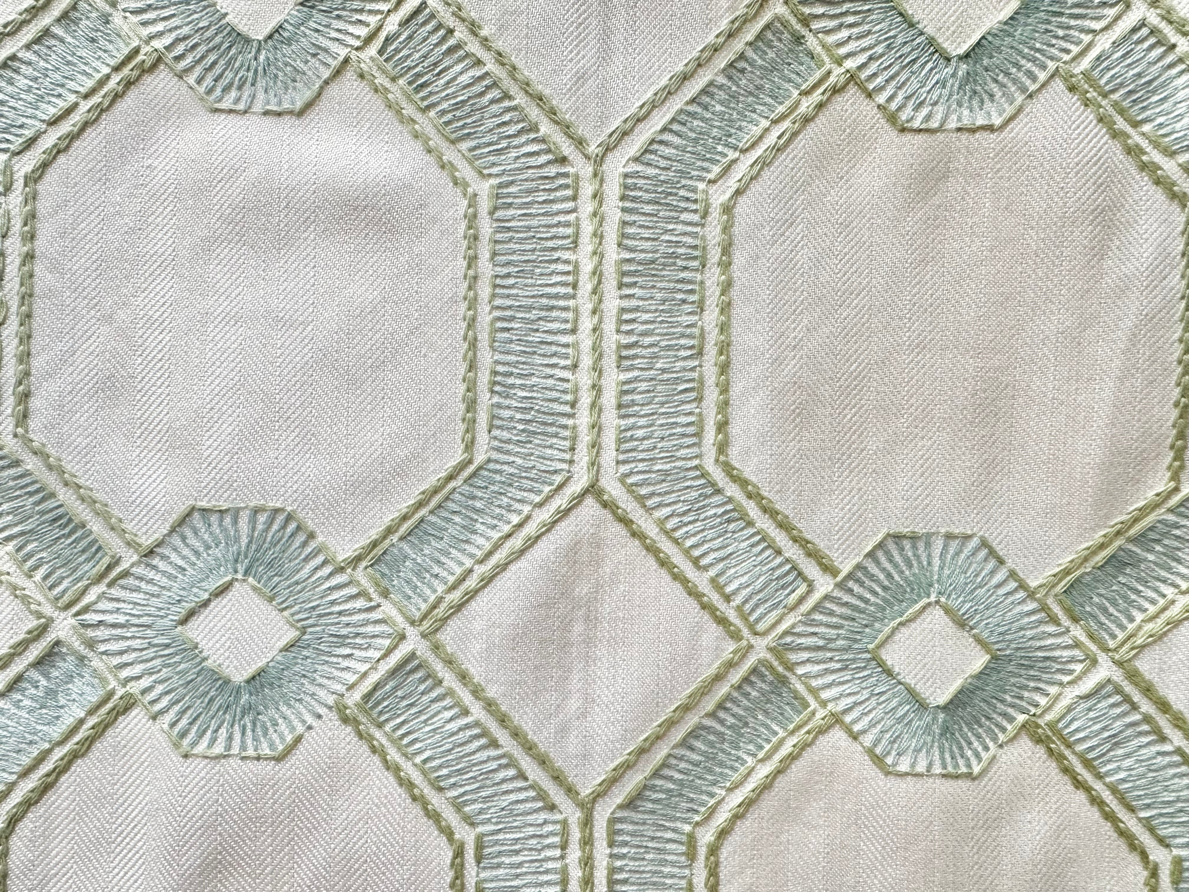 Silky embroidered seaglass fabric on a white off background, featuring delicate coastal-inspired designs, perfect for elegant home decor and upholstery