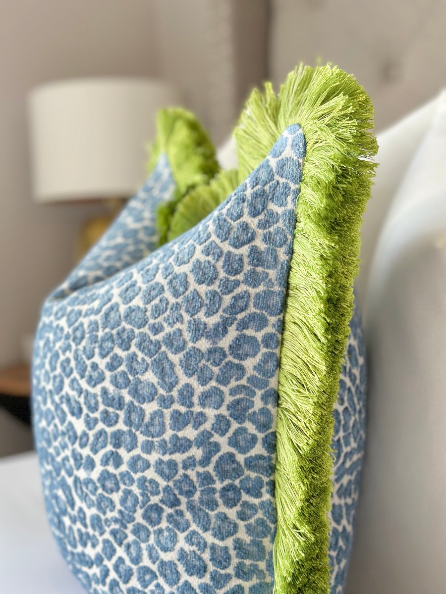 Elegant blue cheetah throw pillow cover with striking green fringe, designed to make a statement and enhance any living space