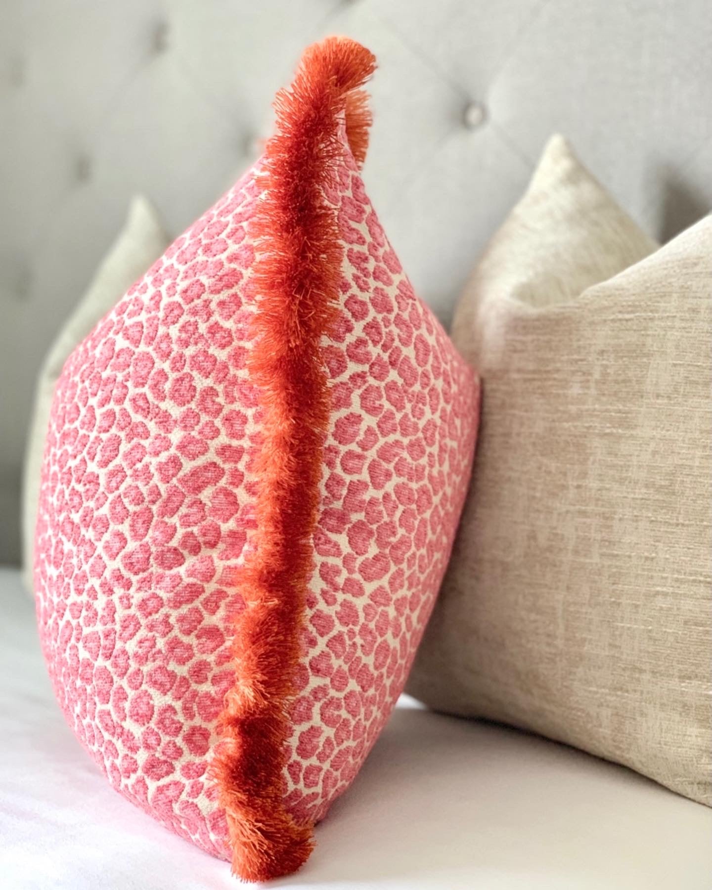 Custom pink cheetah print throw pillow with orange fringe detail - luxurious made-to-order designer fabric accent pillow for bedroom and living room in chinoiserie style decor